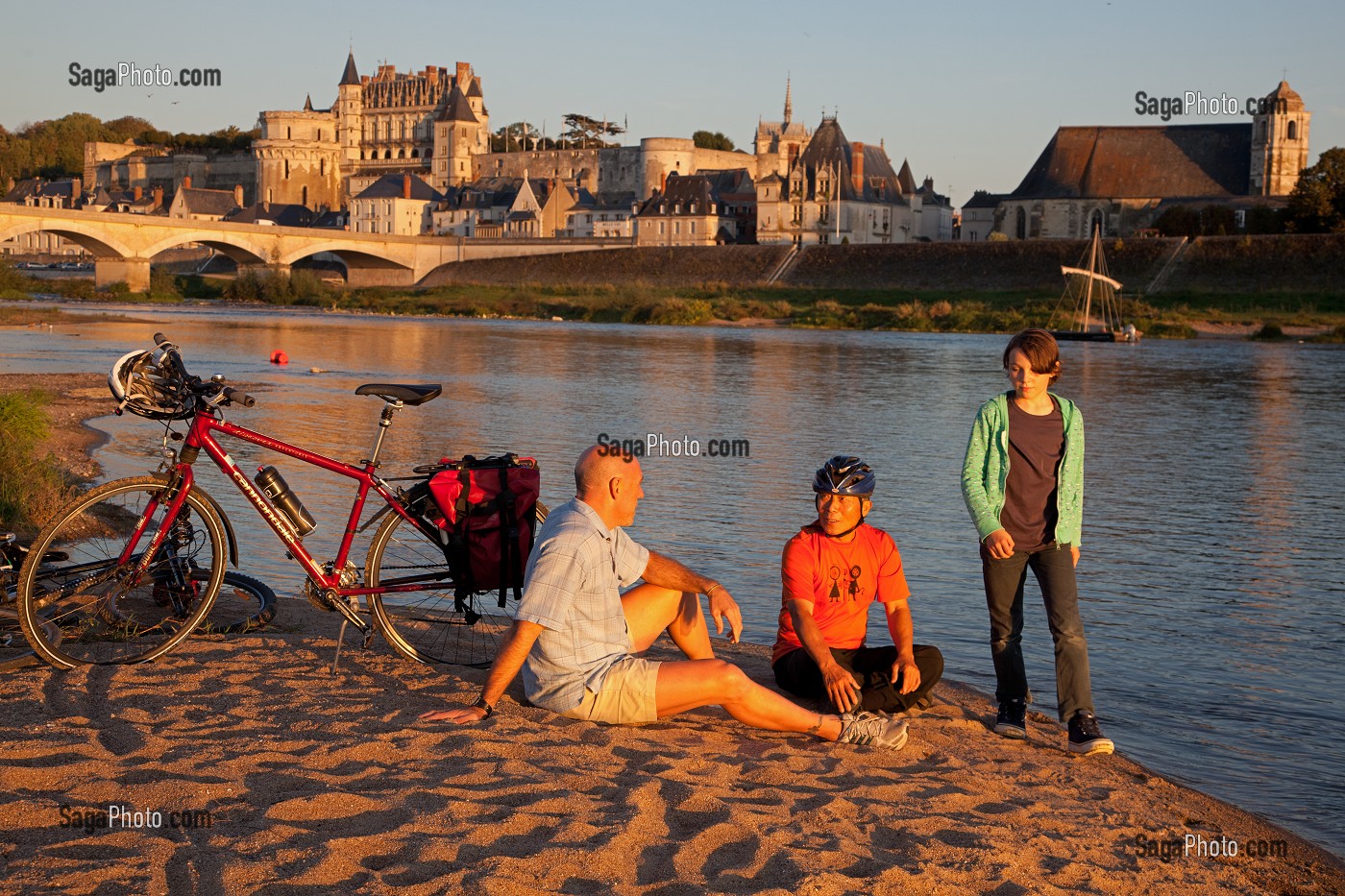 CYCLISTES ASSIS SUR UNE PLAGE DE SABLE SUR LES BORDS DE LA LOIRE, ILE DE LA CROIX ENTRE AMIS DEVANT LE CHATEAU ROYAL SAINT-JEAN, ITINERAIRE DE LA LOIRE A VELO, AMBOISE, INDRE-ET-LOIRE (37), FRANCE 