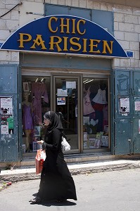 JEUNE FEMME PALESTINIENNE PASSANT DEVANT LA BOUTIQUE DE MODE 'CHIC PARISIEN', BETHLEEM, CISJORDANIE, AUTORITE PALESTINIENNE 