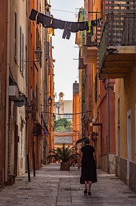 FEMME MARCHANT DANS UNE RUELLE DE LA VIEILLE VILLE DE BASTIA