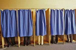 ELECTEURS VOTE DANS UN ISOLOIR DANS UN BUREAU DE VOTE LORS D'UN SCRUTIN  D'ELECTIONS LOCALES 